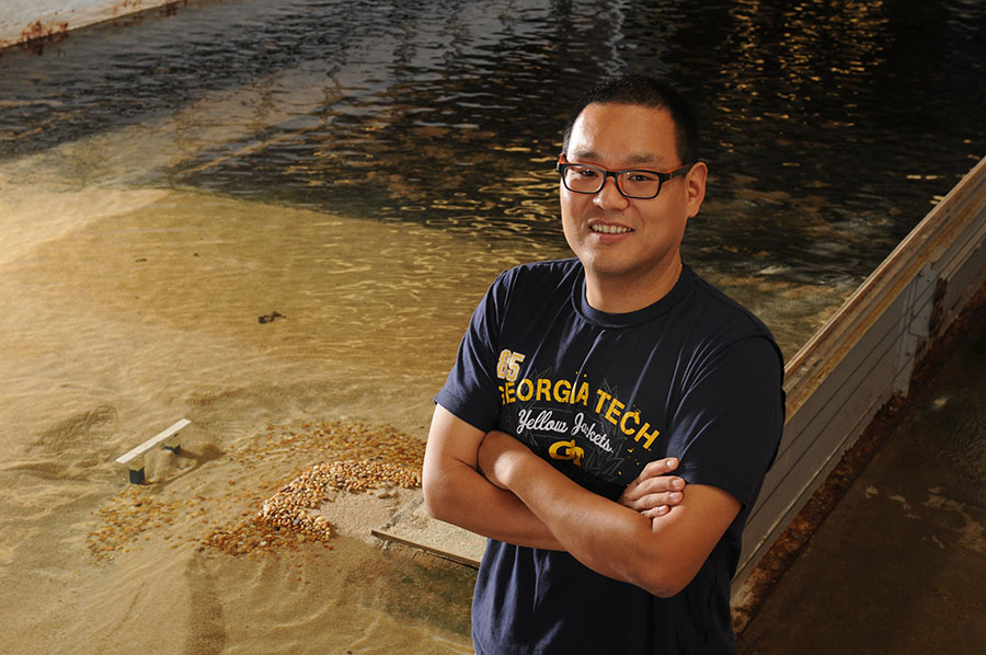 Post-doctoral researcher Seung Ho Hong with the 24-meter long, 4.3-meter wide flume he and Professor Terry Sturm used for their Hilgard Prize-winning paper on erosion around bridge supports during floods, "Clear Water Abutment Scour in a Compound Channel for Extreme Hydrologic Events." They were able to extend a method of predicting the erosion, known as bridge scour, to situations where the bridge opening is submerged and where floodwaters wash over the bridge. Hong is now an assistant professor at West Virginia University. (Photo: Gary Meek)