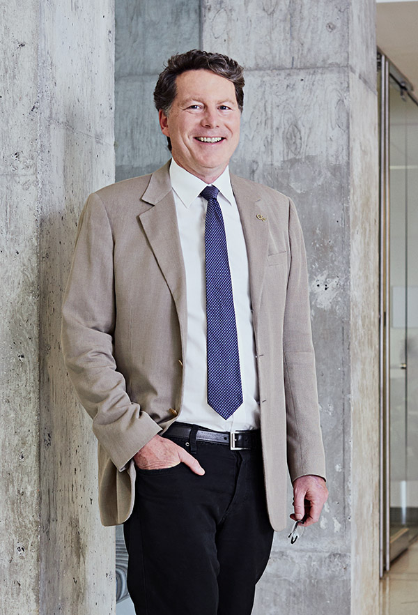 Professor Laurence Jacobs stands next to a concrete column in the Mason Building Lobby.