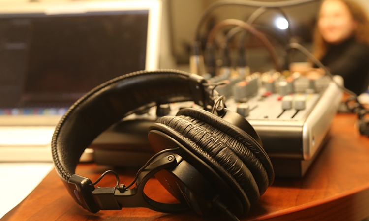 Headphones in front of an audio mixer and laptop during a podcast recording. (Photo: Jess Hunt-Ralston)
