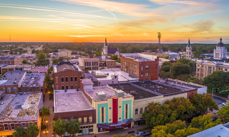 An aerial photo of buildings against a sky at sunset