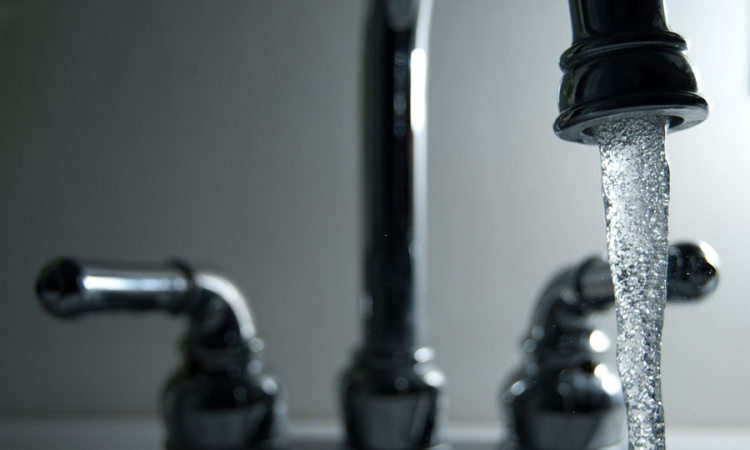 Water pouring from a faucet. (Photo Courtesy: Steve Johnson via Flickr)