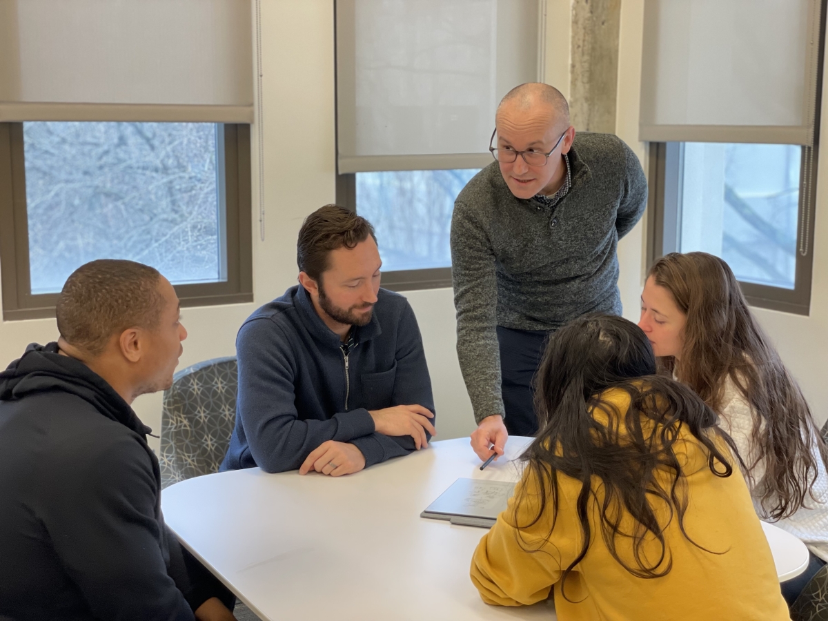 A professor helping a team of students 