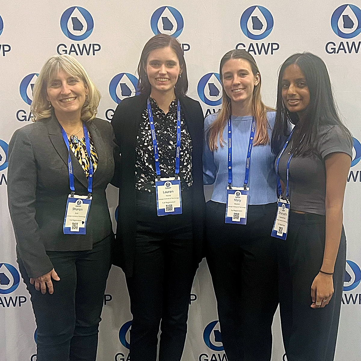 Three students stand with Professor Sharon Just to accept the second-place award