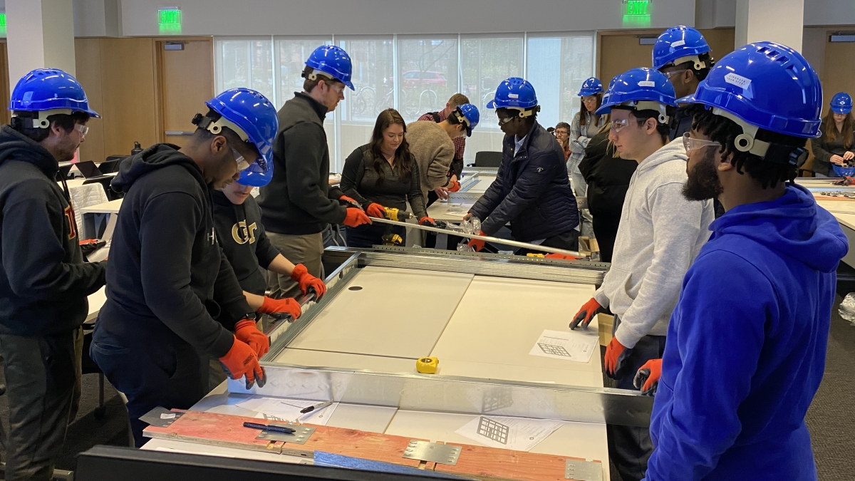 students in blue hard hats working on a project