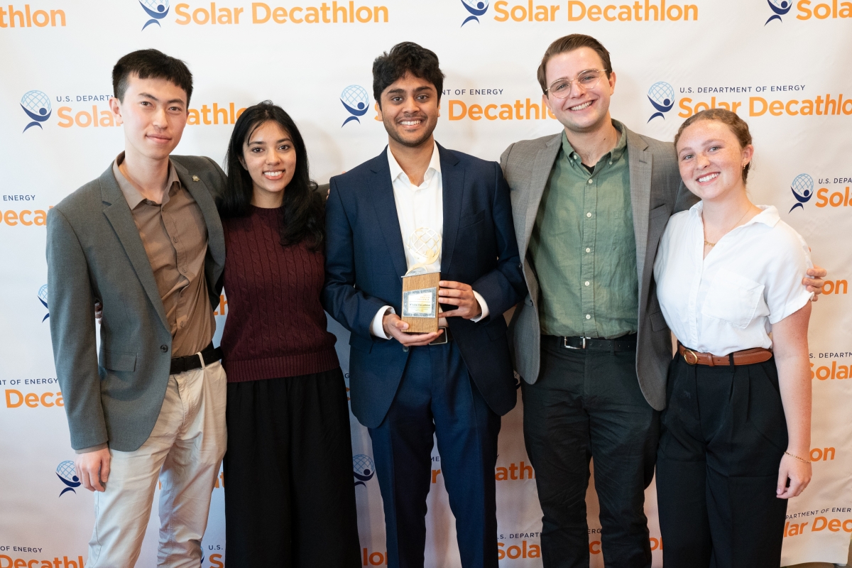 Five students pose with an award