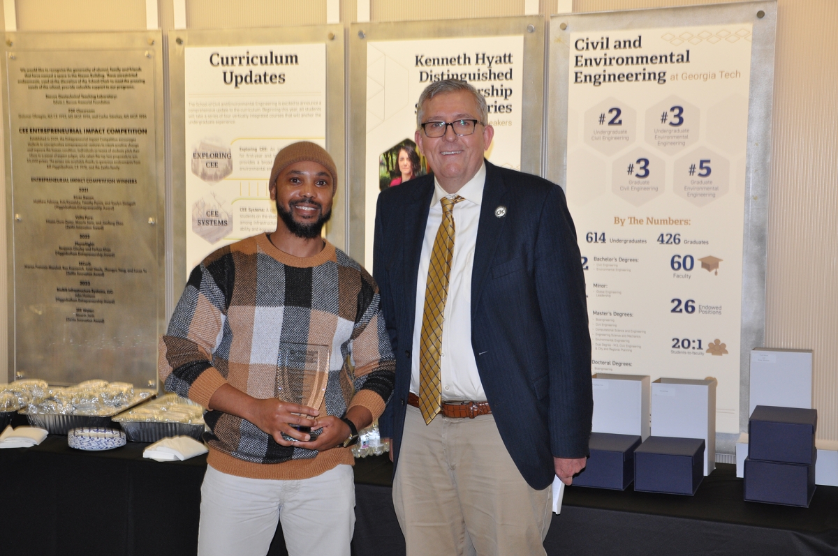 Portrait of Mike Gooden holding award with Chair Don Webster