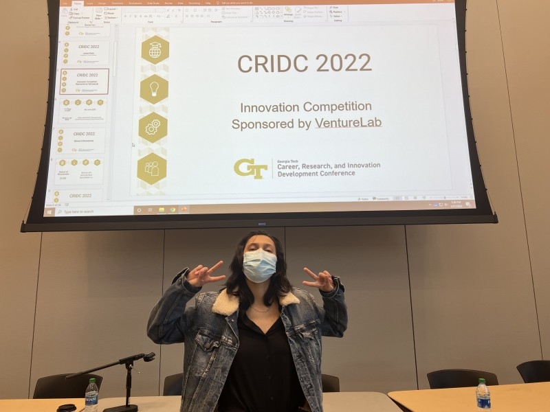 Mourin Jarin poses in front of the 2022 VentureLab Innovation Competition sign at the award ceremony.